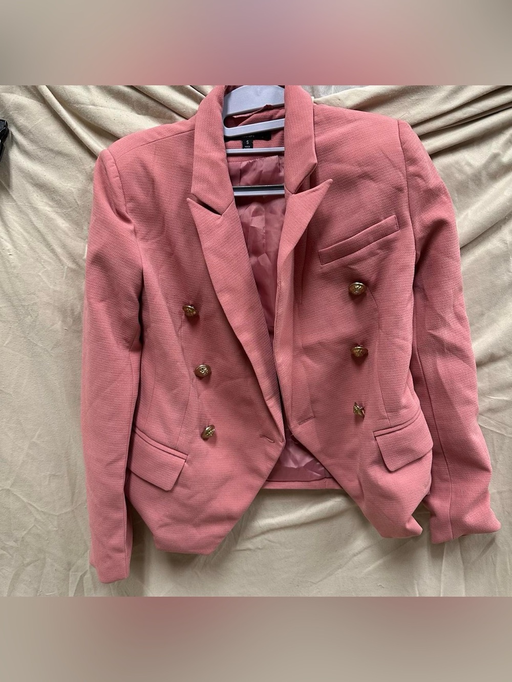 Pink padded shoulder women’s suit jacket with lion buttons.